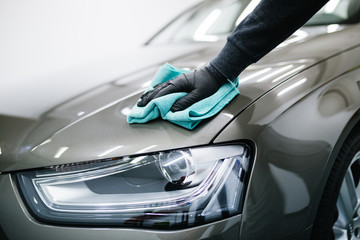 Fototapeta A man cleaning car with microfiber cloth, car detailing (or valeting) concept. Selective focus. obraz