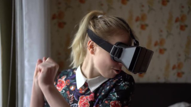 Portrait of beautiful young woman in VR headset at home