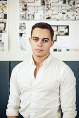 Fototapeta premium Portrait of a smart young man standing with arms crossed