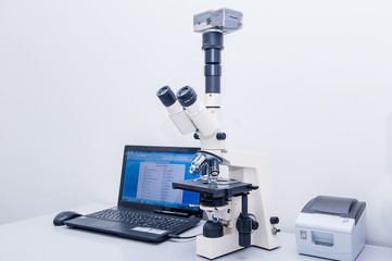 Modern microscope equipped with digital camera and computer in clinic laboratory. Selective focus