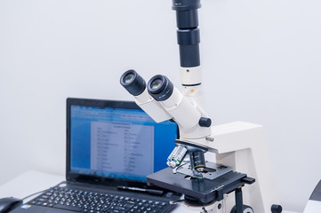 Modern microscope equipped with digital camera and computer in clinic laboratory. Selective focus