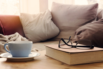 cup and book on table in front of sofa