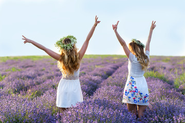 Two girls in a lavender field. Happy women Having fun. Friendship Day Portrait