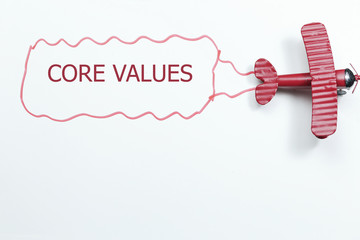 writing Core Values red toy airplane with talk bubble on white background