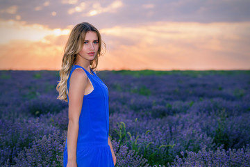 Beautiful Girl in lavender Field at sunset. Pretty woman Provence style in a dress and flowers wreath. Beautiful blonde woman in the lavender field on sunset Amazing portrait