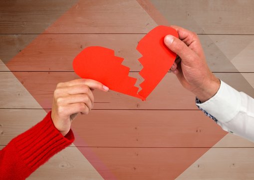 Couple holding broken heart against wooden background
