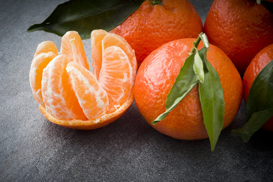 Ripe orange tangerine clove on the gray table