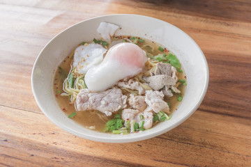 Close up thai spicy pork noodle with big egg.