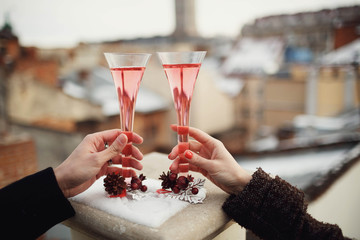 male and female hand holding glasses of pink champagne
