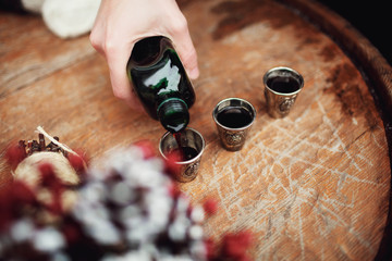 man pours Jägermeister in three small glasses