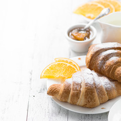 Croissant jam coffee orange jice at white wooden table. 