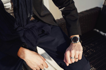 Man's hands with wedding ring and black wristwatch