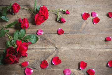 Red roses on wooden background.