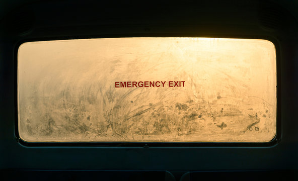 Emergency exit sign on a misty bus window