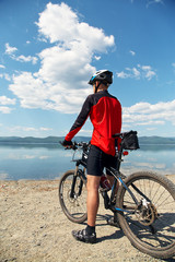 man with bike on a mountain lake