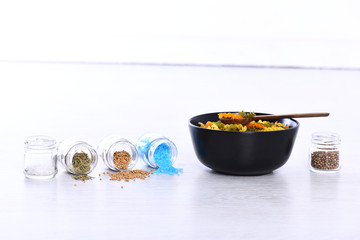 plate, pasta, spoon, spices in jars on white grey background