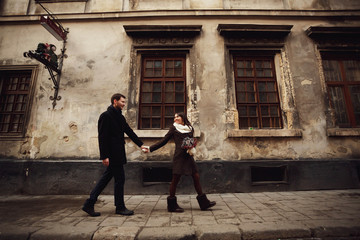 young man and woman walks near old building