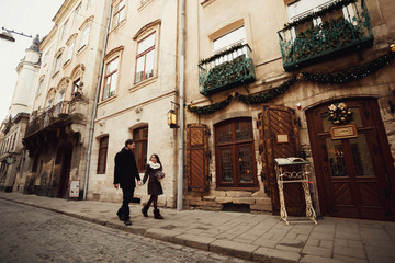 young man and woman walks near old building