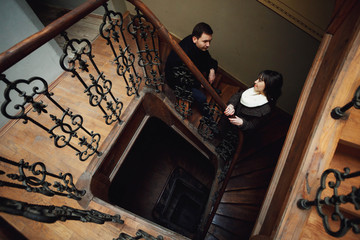 young man and woman standing on old stairs
