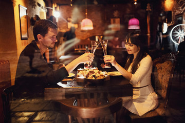 beautiful and young couple sitting in a cozy cafe and drinking c