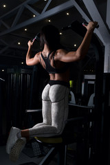 young girl with sexual inflated figure, in the gym, pulled on the bar