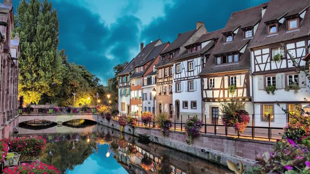 Colorful traditional french houses on the side of river in the evening in Colmar, France (static image with animated sky and water)
