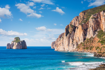 High cliffs of Mediterranean coast, "Pan di Zucchero" stack rock in Masua, west coast of Sardinia, Italy