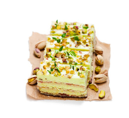 Slices  of layered cake with pistachio isolated on white