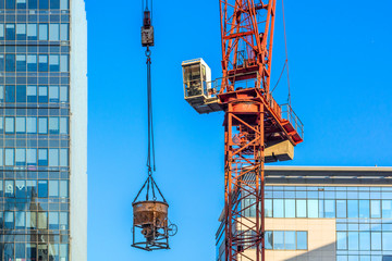 The crane against modern buildings under construction.