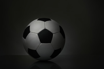 soccer ball with reflection on the table on a dark background