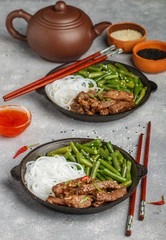 Fried spicy beef with sesame seeds, green beans and rice noodles