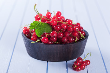 Ripe red currant in wooden bowl