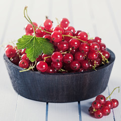 Ripe red currant in wooden bowl