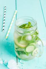 Refreshing summer drink - detox cocktail of mint, cucumber and lemon. On a light blue wooden table, bright sunlight, copy space