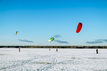 Athletes engaged in Snowkiting on the ice lake Khepoyarvi