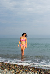 Fototapeta na wymiar Portrait of beautiful woman in pink bikini on sea background. Woman resting in Batumi, Georgia