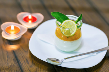 milk dessert with lime at the table by candlelight