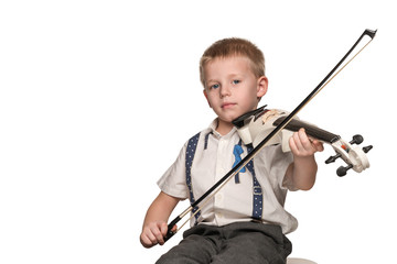 Little beautiful boy in shirt sitting in a chair, playing the electric violin, isolated on a white background