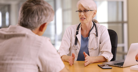 Obraz premium Confident doctor discussing health concerns with elderly man