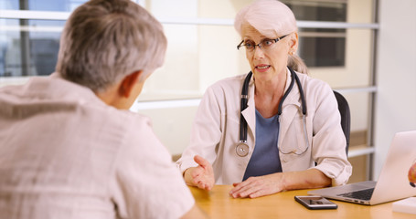Obraz premium Senior woman doctor talking to elderly patient in the office