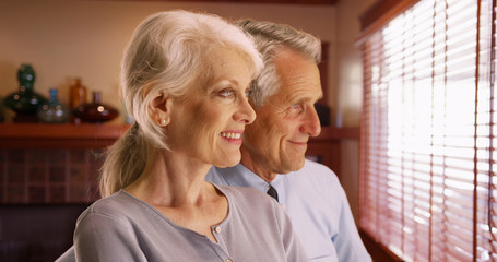 Closeup of happy senior couple looking out the window