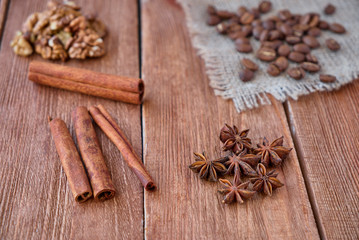Cinnamon sticks, anise, coffee beans and nuts on a wooden background