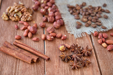 Cinnamon sticks, anise, coffee beans and nuts on a wooden background