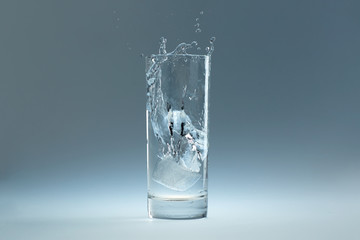 ice cube falls in a glass of water