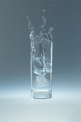 ice cube falls in a glass of water