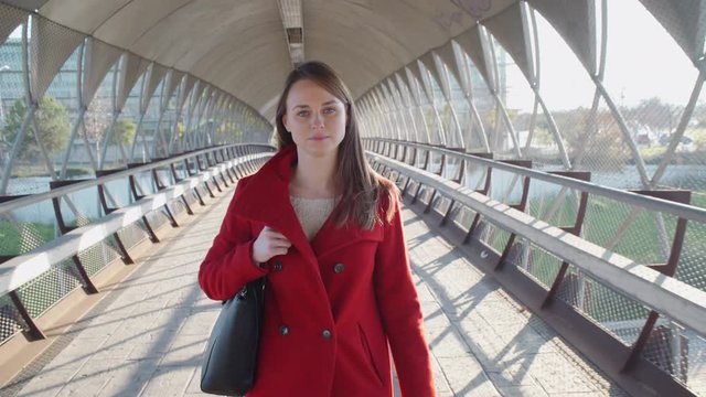 Beautiful woman walking in the city and looking at camera serious.