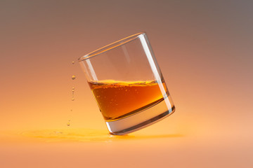 obliquely standing whiskey glass with drops