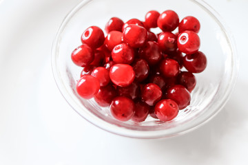 Ripe juicy red cherry in a transparent plate
