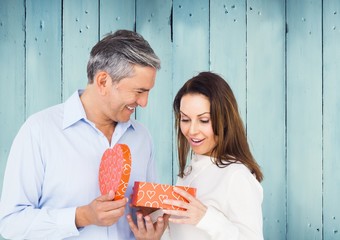 Couple holding heart box against blue panel