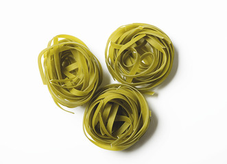 Res rolls of vegetable spaghetti on white background. Italian pasta. Horizontal shoot.